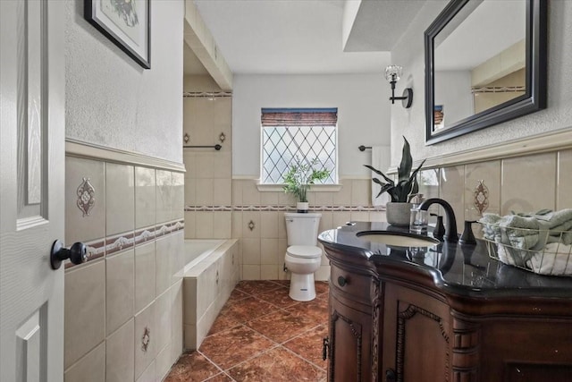 7741 Bearden Ln, Dallas, TX 75227 - full bathroom featuring vanity, toilet, tile patterned floors, a wainscoted wall, and tile walls