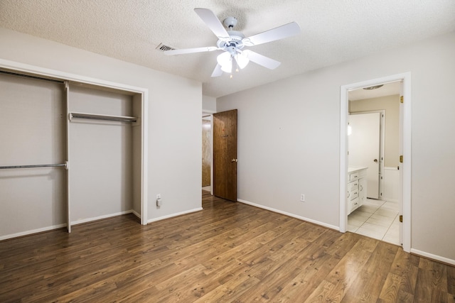 4508 Ramsgate Ct, Arlington, TX 76013 - unfurnished bedroom featuring a closet, wood finished floors, a textured ceiling, ensuite bathroom, and a ceiling fan