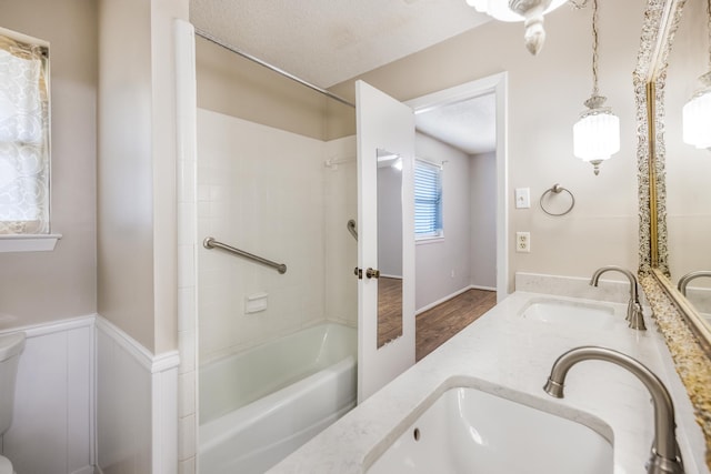 4508 Ramsgate Ct, Arlington, TX 76013 - bathroom with tub / shower combination, a textured ceiling, double vanity, and wood finished floors