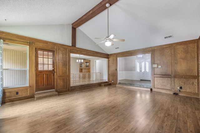 4508 Ramsgate Ct, Arlington, TX 76013 - unfurnished living room featuring wood finished floors, beam ceiling, a ceiling fan, a chandelier, and a decorative wall