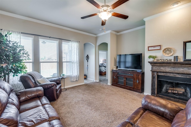 11408 Aquilla Dr, Frisco, TX 75036 - carpeted living area featuring arched walkways, a ceiling fan, crown molding, baseboards, and a fireplace