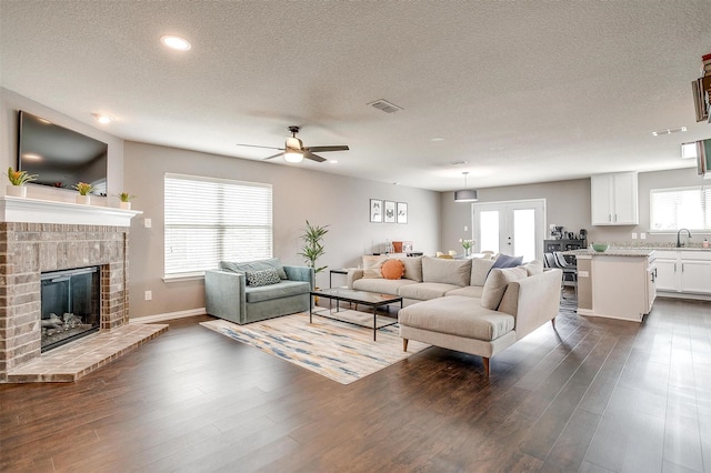 2924 Whitetail Chase Dr, Fort Worth, TX 76108 - living area featuring a textured ceiling, a ceiling fan, dark wood-style flooring, a fireplace, and recessed lighting