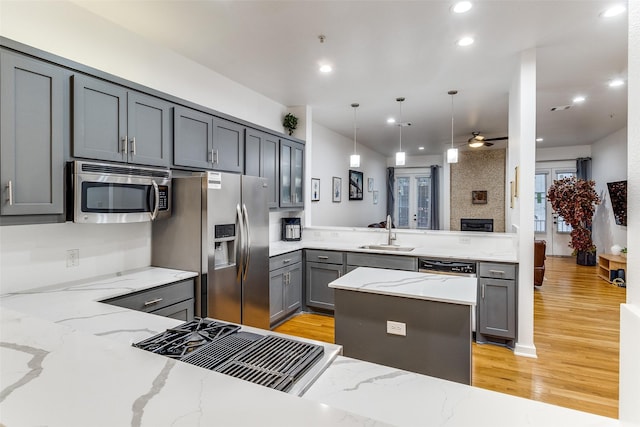 3320 Douglas Ave Unit C, Dallas, TX 75219 - kitchen with appliances with stainless steel finishes, a sink, gray cabinets, light wood-style flooring, and recessed lighting