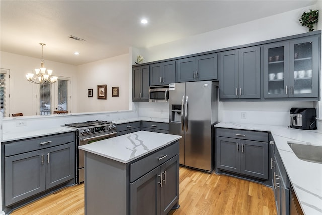 3320 Douglas Ave Unit C, Dallas, TX 75219 - kitchen with appliances with stainless steel finishes, a chandelier, gray cabinets, light wood-type flooring, and recessed lighting