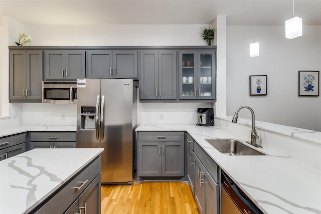3320 Douglas Ave Unit C, Dallas, TX 75219 - kitchen with appliances with stainless steel finishes, gray cabinets, a sink, and light stone counters