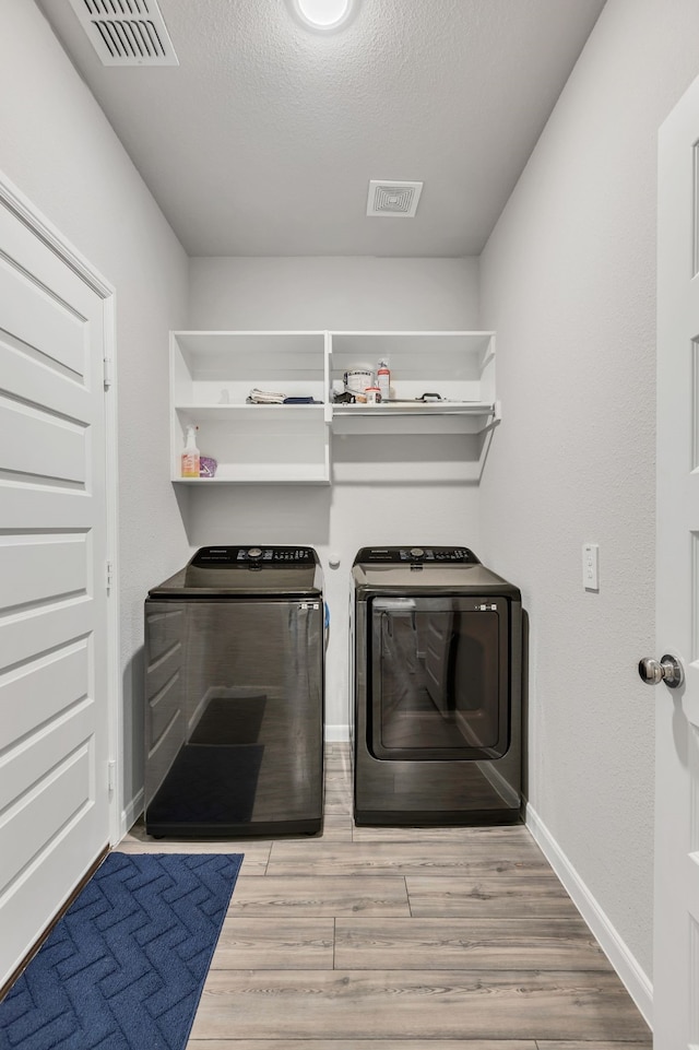 7207 Village Falls Ln, Royse City, TX 75189 - laundry room featuring independent washer and dryer, baseboards, wood finished floors, and a textured ceiling