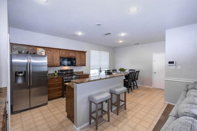 10940 Dillon St, Fort Worth, TX 76179 - kitchen with stainless steel appliances, light floors, a kitchen breakfast bar, a kitchen island, and recessed lighting