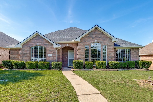 1721 Chapman Dr, Mesquite, TX 75149 - view of front of house featuring brick siding, a front yard, and a shingled roof