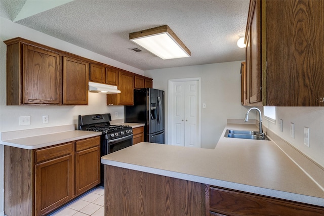 1721 Chapman Dr, Mesquite, TX 75149 - kitchen with under cabinet range hood, black appliances, a sink, a peninsula, and a textured ceiling