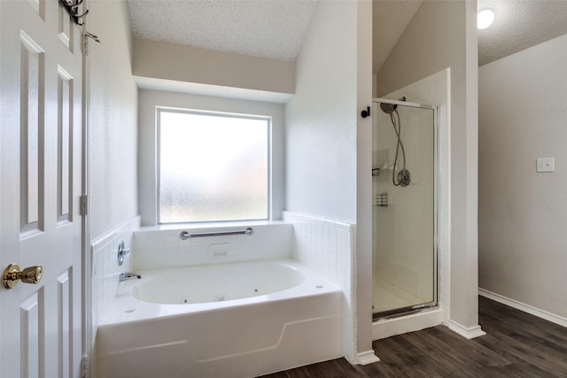 1721 Chapman Dr, Mesquite, TX 75149 - bathroom with a tub with jets, a shower stall, wood finished floors, a textured ceiling, and baseboards