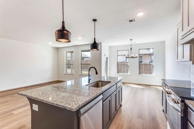 514 Hillcrest Cir, Justin, TX 76247 - kitchen with a sink, stainless steel appliances, light wood-style floors, light stone countertops, and recessed lighting