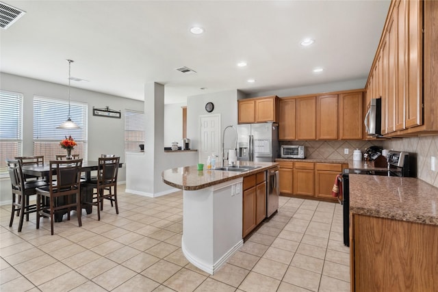 403 Elmcrest Ct, Forney, TX 75126 - kitchen with appliances with stainless steel finishes, a sink, decorative backsplash, light tile patterned flooring, and recessed lighting