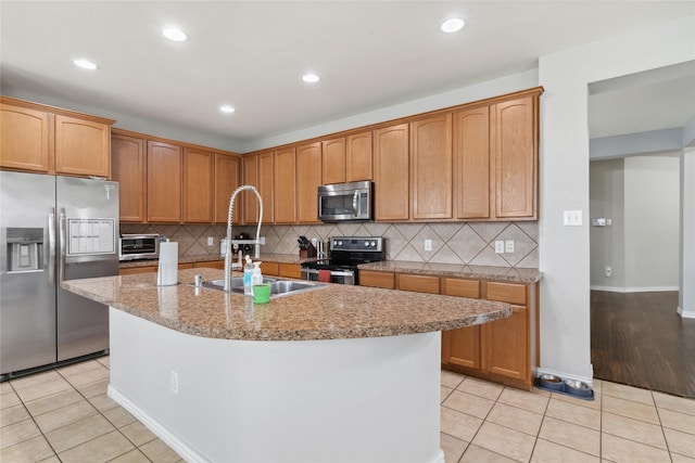 403 Elmcrest Ct, Forney, TX 75126 - kitchen with stainless steel appliances, a sink, light tile patterned flooring, a center island with sink, and recessed lighting