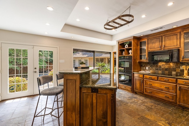 8907 Meadowknoll Dr, Dallas, TX 75243 - kitchen with black appliances, stone tile flooring, recessed lighting, a kitchen bar, and french doors