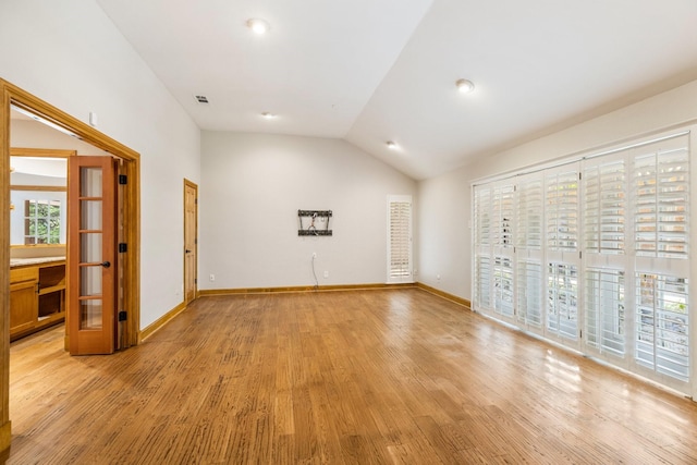 8907 Meadowknoll Dr, Dallas, TX 75243 - unfurnished living room featuring plenty of natural light, light wood finished floors, vaulted ceiling, and baseboards