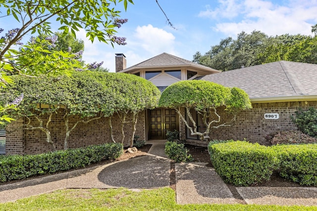 8907 Meadowknoll Dr, Dallas, TX 75243 - view of front of property featuring brick siding and a chimney