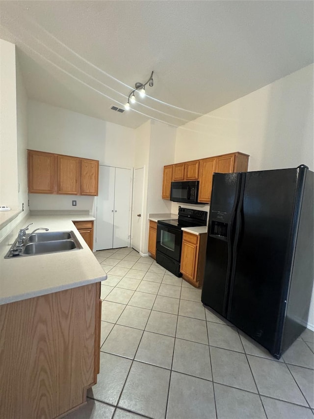836 Cedar Ridge Ln, Burleson, TX 76028 - kitchen with black appliances, a sink, light tile patterned floors, light countertops, and brown cabinets