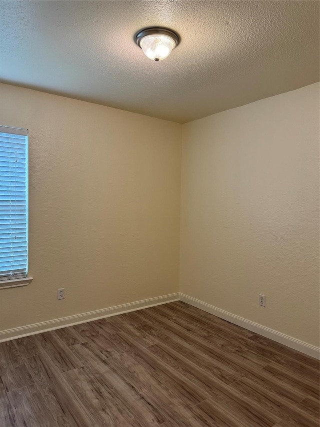 836 Cedar Ridge Ln, Burleson, TX 76028 - empty room featuring dark wood-style flooring, a textured ceiling, and baseboards