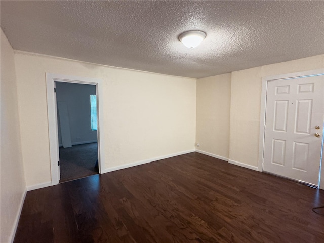 921 Longino St, Sulphur Springs, TX 75482 - empty room featuring dark wood-style floors, a textured ceiling, and baseboards