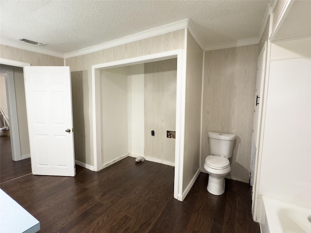 921 Longino St, Sulphur Springs, TX 75482 - full bath with a textured ceiling, wood finished floors, toilet, ornamental molding, and a bathtub