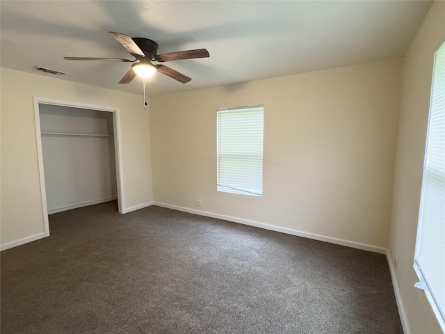 921 Longino St, Sulphur Springs, TX 75482 - unfurnished bedroom with dark colored carpet, a closet, multiple windows, and baseboards