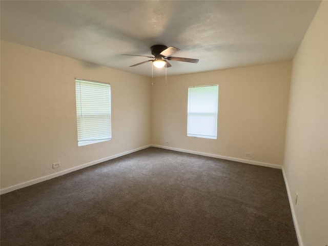 921 Longino St, Sulphur Springs, TX 75482 - unfurnished room with healthy amount of natural light, a ceiling fan, baseboards, and dark colored carpet