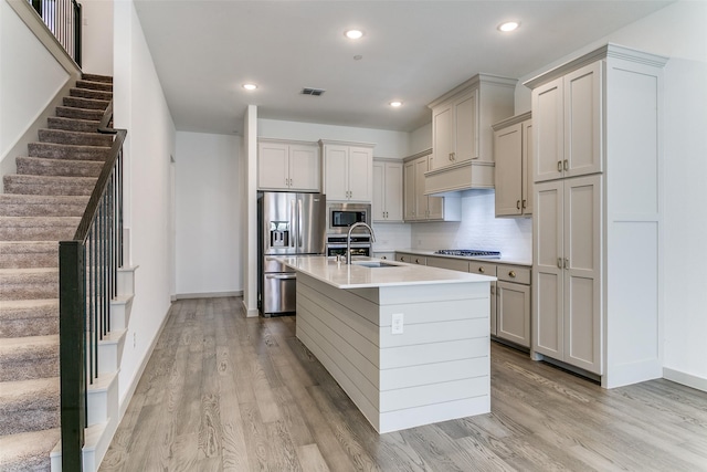135 Claire Dr, Trophy Club, TX 76262 - kitchen with appliances with stainless steel finishes, light wood-style floors, light countertops, a center island with sink, and baseboards