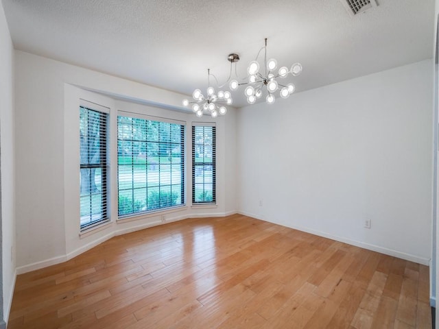 3414 Country Club Rd, Pantego, TX 76013 - empty room with a chandelier, light wood-type flooring, baseboards, and a textured ceiling