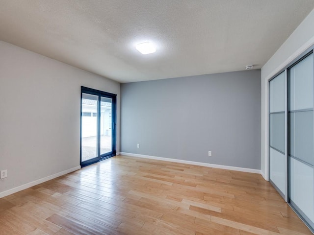 3414 Country Club Rd, Pantego, TX 76013 - spare room featuring light wood-style flooring, baseboards, and a textured ceiling