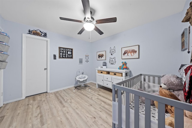 22 Buttercup Cir, Waco, TX 76708 - bedroom with light wood-style flooring, a crib, a ceiling fan, and baseboards