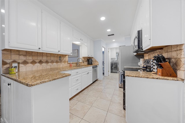 22 Buttercup Cir, Waco, TX 76708 - kitchen with stainless steel appliances, a sink, white cabinets, backsplash, and recessed lighting