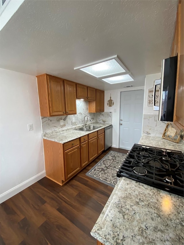 4313 Windsor Dr, Garland, TX 75042 - kitchen with a sink, stainless steel appliances, brown cabinets, and decorative backsplash