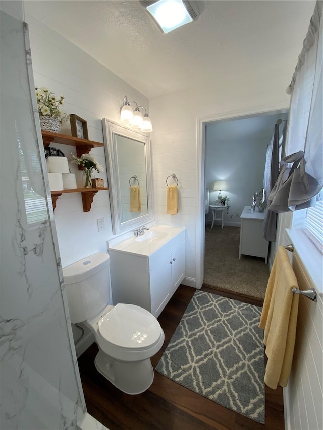 4313 Windsor Dr, Garland, TX 75042 - bathroom with vanity, toilet, and wood finished floors