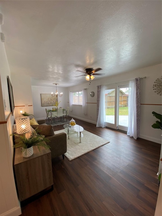 4313 Windsor Dr, Garland, TX 75042 - living area featuring dark wood-style floors, baseboards, a ceiling fan, and a chandelier