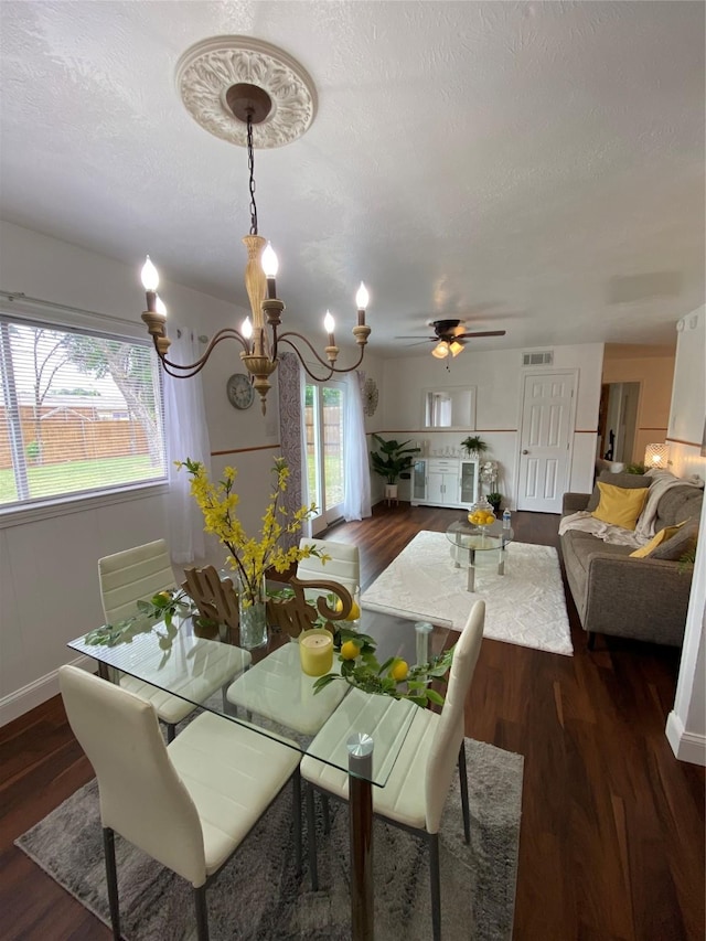 4313 Windsor Dr, Garland, TX 75042 - dining area with dark wood-type flooring, a chandelier, a ceiling fan, baseboards, and a textured ceiling