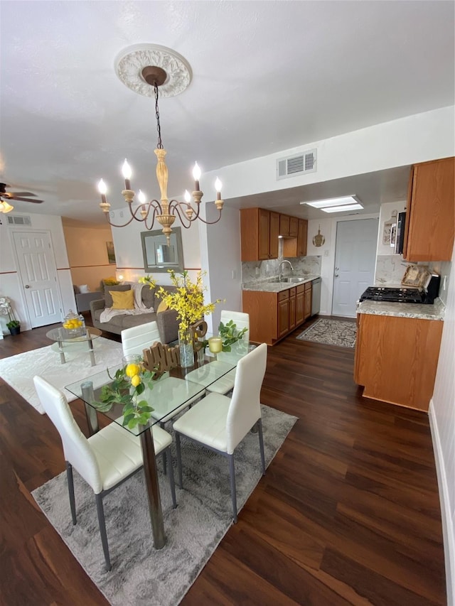 4313 Windsor Dr, Garland, TX 75042 - dining space featuring dark wood finished floors, a chandelier, and a ceiling fan