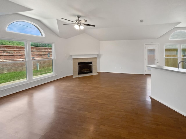 4162 Stone Hollow Way, Fort Worth, TX 76040 - unfurnished living room with lofted ceiling, a ceiling fan, a tiled fireplace, dark wood-style flooring, and baseboards