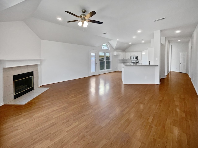 4162 Stone Hollow Way, Fort Worth, TX 76040 - unfurnished living room with lofted ceiling, light wood-type flooring, ceiling fan, a tiled fireplace, and recessed lighting