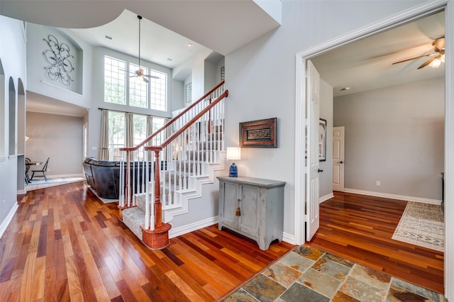 2750 Bandolier Ln, Frisco, TX 75033 - stairs with wood-type flooring, arched walkways, baseboards, a towering ceiling, and a ceiling fan