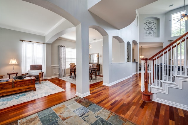 2750 Bandolier Ln, Frisco, TX 75033 - foyer featuring wood-type flooring, crown molding, plenty of natural light, stairs, and arched walkways