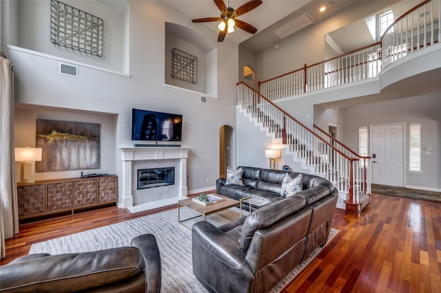 2750 Bandolier Ln, Frisco, TX 75033 - living area with hardwood / wood-style floors, a ceiling fan, arched walkways, stairway, and a high ceiling