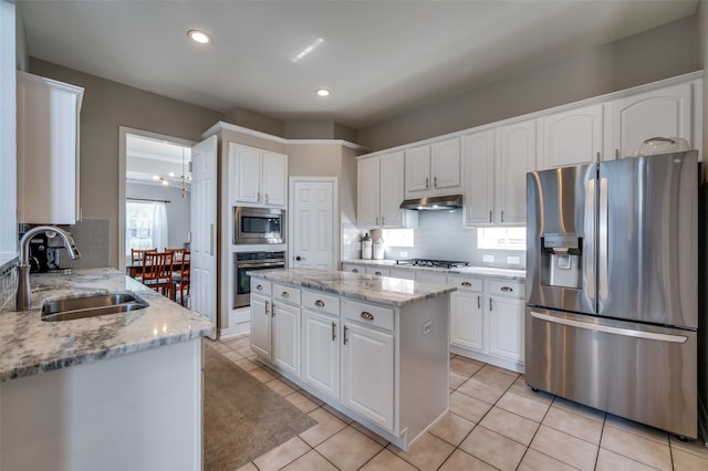 2750 Bandolier Ln, Frisco, TX 75033 - kitchen with appliances with stainless steel finishes, a sink, under cabinet range hood, backsplash, and white cabinets