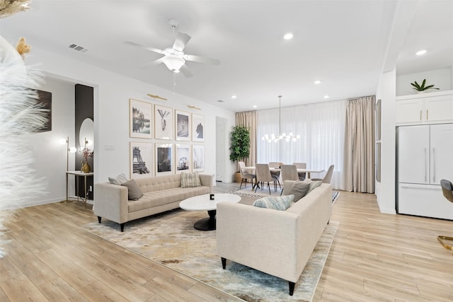 8509 Barnbougle Dunes Dr, Mckinney, TX 75070 - living area featuring light wood finished floors, a ceiling fan, a chandelier, arched walkways, and recessed lighting