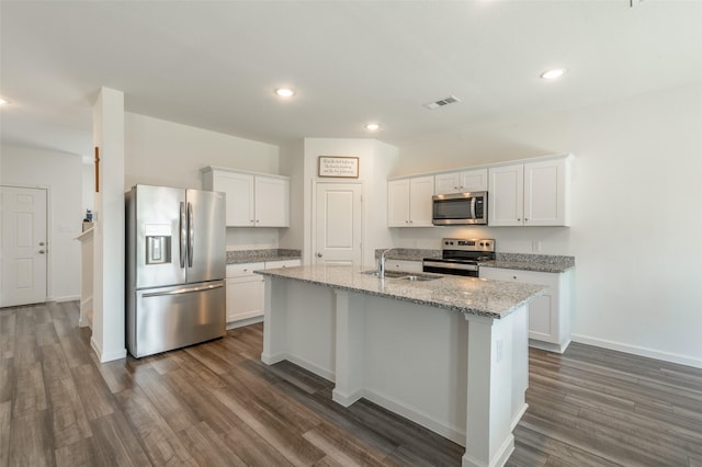 1401 Ancer Way, Fort Worth, TX 76052 - kitchen featuring stainless steel appliances, a sink, dark wood-style floors, a center island with sink, and white cabinets