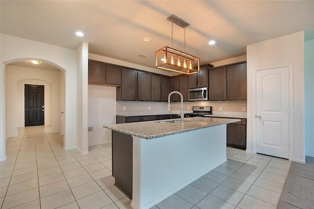 2154 Slow Stream Dr, Royse City, TX 75189 - kitchen featuring a sink, light tile patterned floors, stainless steel microwave, dark brown cabinetry, and stove