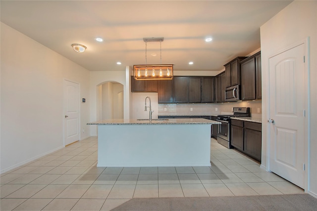 2154 Slow Stream Dr, Royse City, TX 75189 - kitchen with appliances with stainless steel finishes, a sink, light stone countertops, arched walkways, and recessed lighting