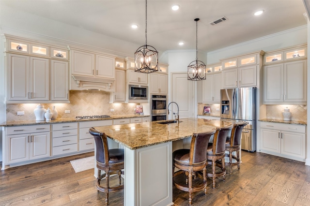 7617 Windsor, The Colony, TX 75056 - kitchen with appliances with stainless steel finishes, backsplash, a sink, a center island with sink, and ornamental molding