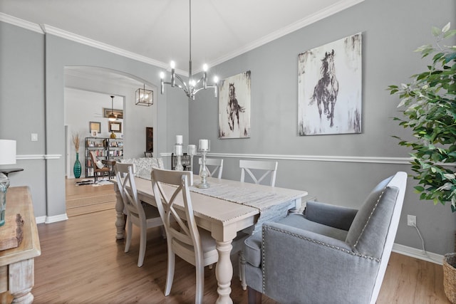 8228 Shady Valley Dr, Benbrook, TX 76116 - dining area featuring a chandelier, wood finished floors, ornamental molding, arched walkways, and baseboards