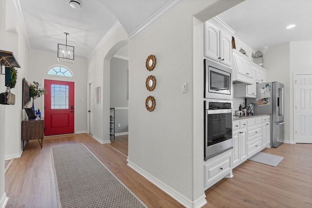 8228 Shady Valley Dr, Benbrook, TX 76116 - foyer featuring ornamental molding, light wood-type flooring, arched walkways, and baseboards