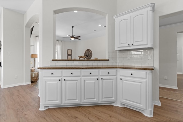 8228 Shady Valley Dr, Benbrook, TX 76116 - kitchen featuring arched walkways, ceiling fan, baseboards, and light wood-style flooring